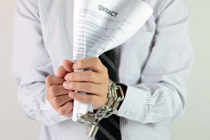 25659335 - businessman hands with tied with chains and hold contract